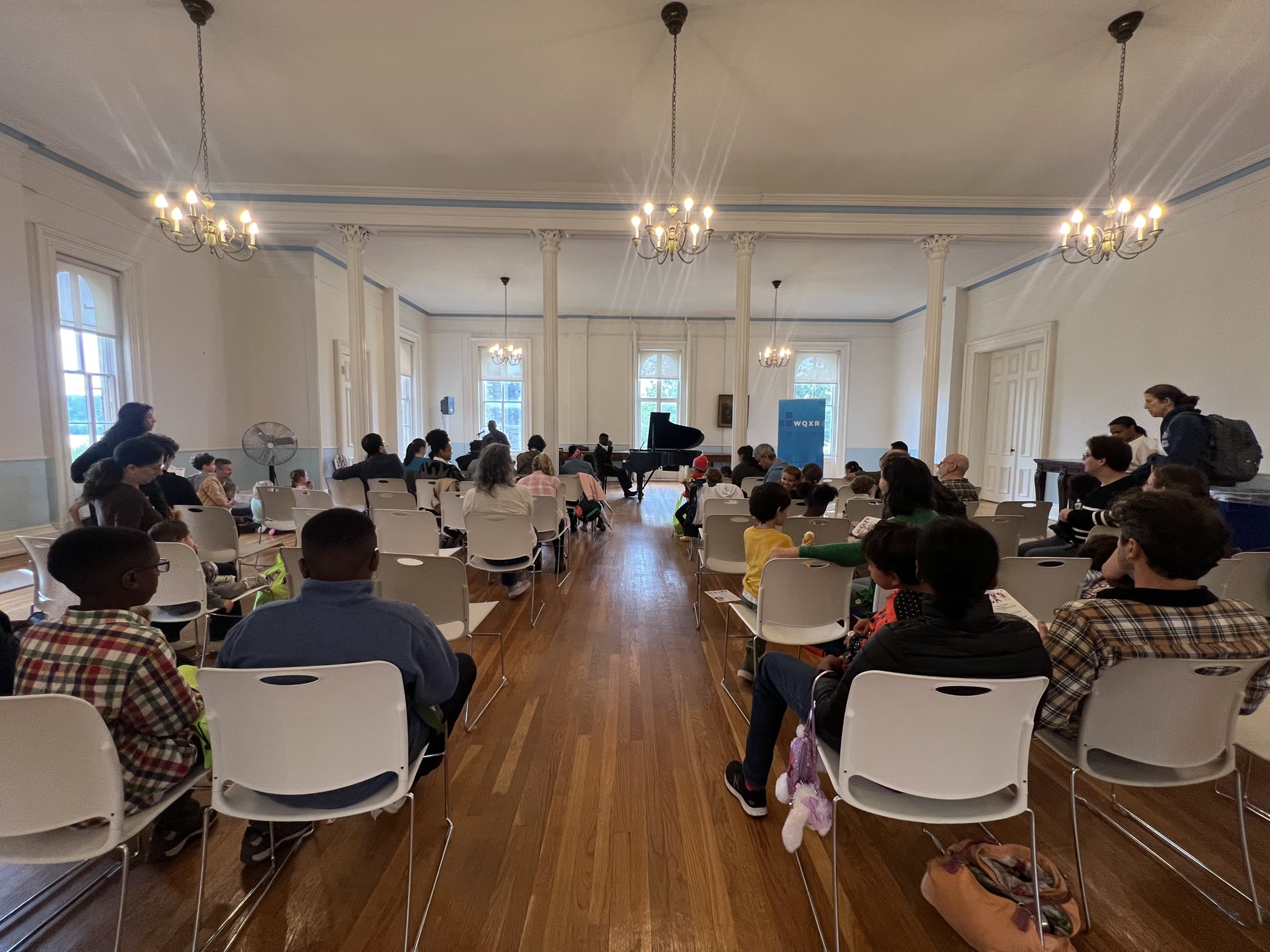 A full room of children and families at the WQXR Bronx Classical Kids Fair as Kyle P. Walker performs