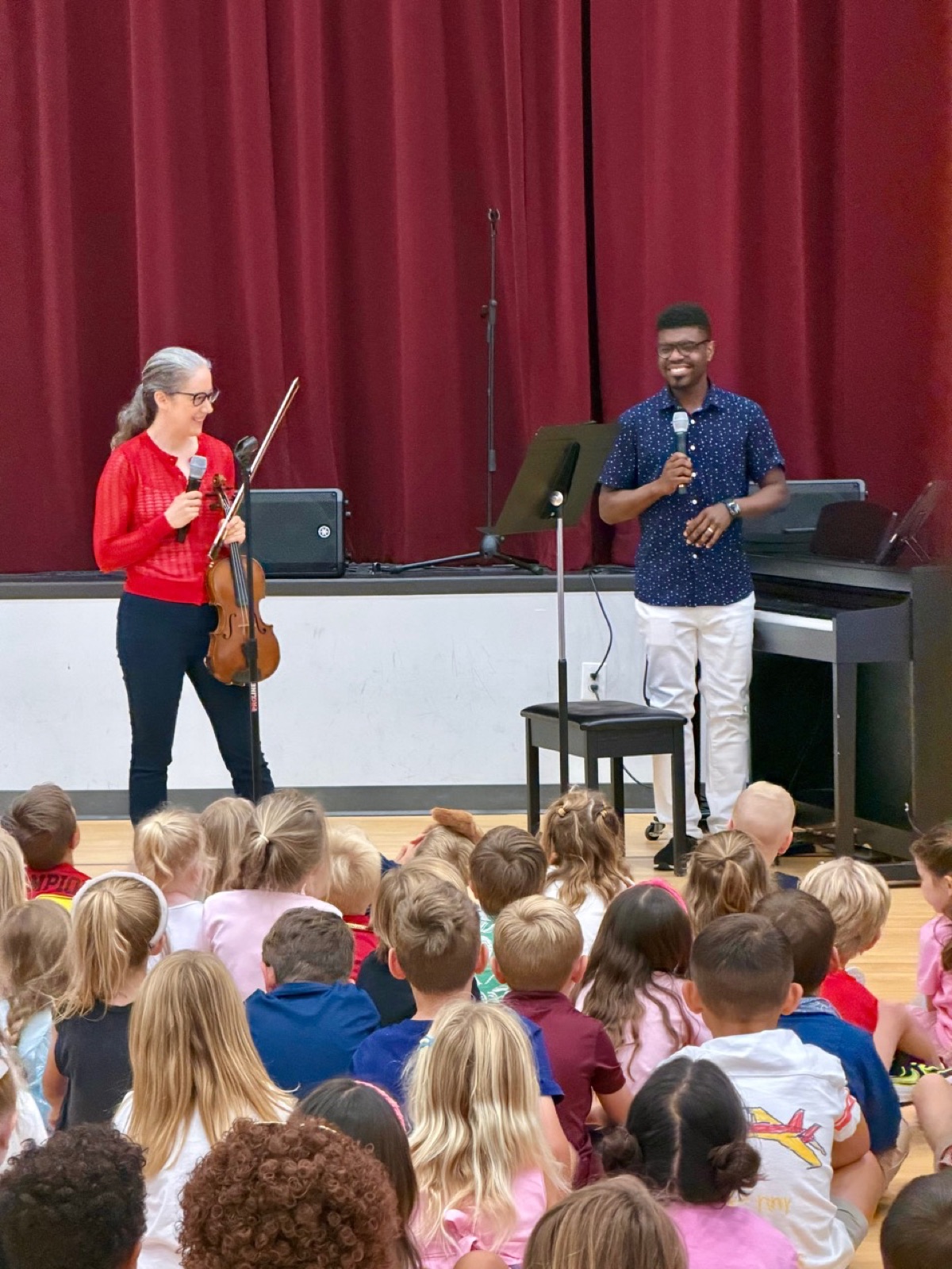 Kyle P. Walker speaking with young students during a school program